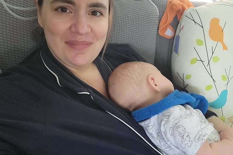 Image of postpartum doula Sabrina holding her baby during a nap.