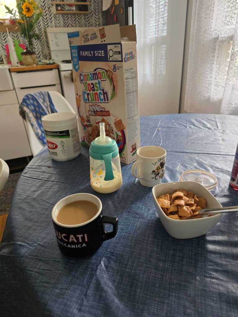 A breakfast table showing cereal, milk, and a bottle of breastmilk
